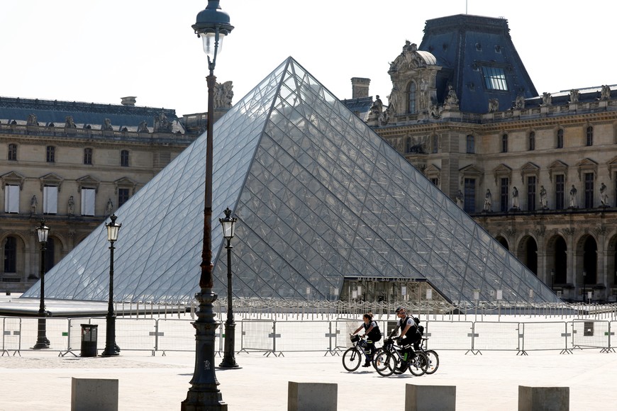 Policemen rides past the closed Louvre Pyramid designed by Chinese-born U.S. architect Ieoh Ming Pei as a lockdown is imposed to slow the rate of the coronavirus disease (COVID-19) in Paris, France, April 16, 2020. REUTERS/Charles Platiau