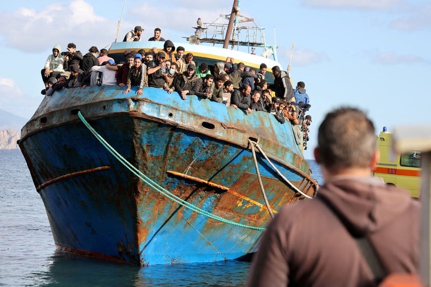 FILE PHOTO: Migrants stand onboard a fishing boat in the port of Paleochora after a rescue operation off the island of Crete, Greece, November 22, 2022. REUTERS/Stringer/File Photo