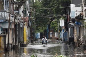 A man rides a motorcycle through a waterlogged street in Mandvi before the arrival of cyclone Biparjoy in the western state of Gujarat, India, June 15, 2023. REUTERS/Francis Mascarenhas