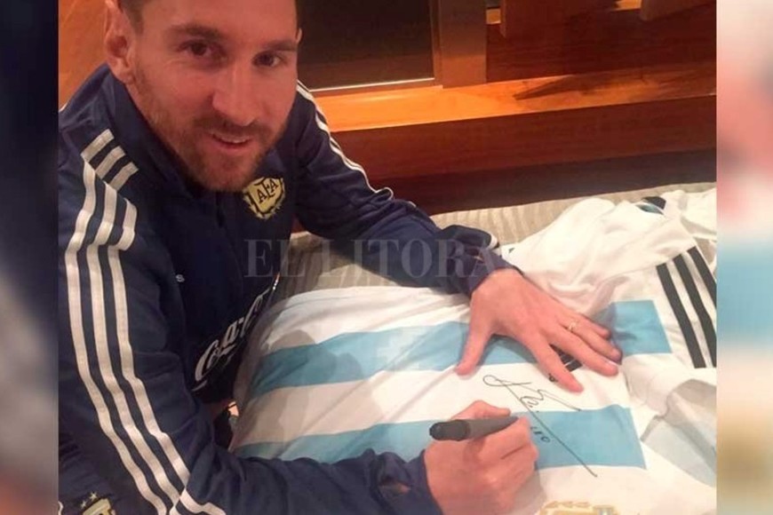 Messi firmando una camiseta de Argentina que luego fue sorteada por El Litoral