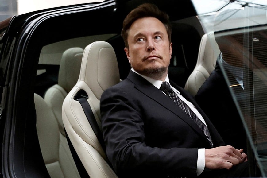 FILE PHOTO: Tesla Chief Executive Officer Elon Musk gets in a Tesla car as he leaves a hotel in Beijing, China May 31, 2023. REUTERS/Tingshu Wang/File Photo