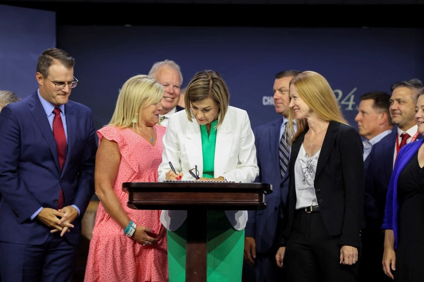 Iowa Governor Kim Reynolds signs the "fetal heartbeat" bill, banning abortions after 6 weeks of pregnancy, during the Family Leadership Summit at the Iowa Events Center in Des Moines, Iowa, U.S., July 14, 2023. REUTERS/Scott Morgan