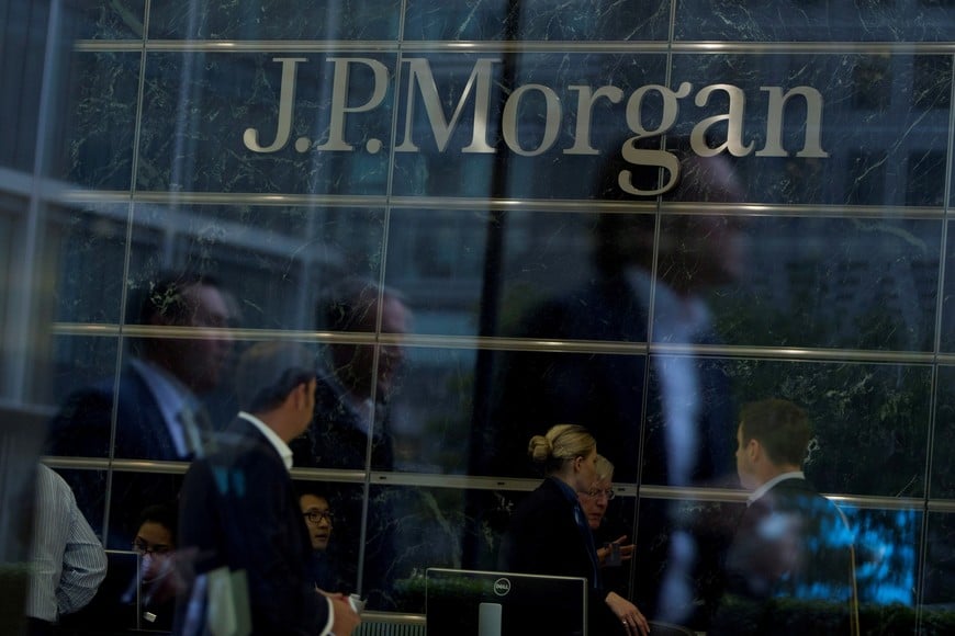 FILE PHOTO: Workers are reflected in the windows of the Canary Wharf offices of JP Morgan in London September 19, 2013. REUTERS/Neil Hall/File Photo