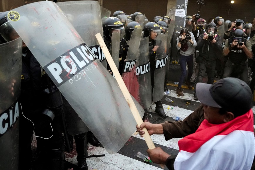 Members of the media work as an anti-government demonstrator uses a stick against riot police during a protest against Peru's President Dina Boluarte in Lima, Peru July 19, 2023. REUTERS/Angela Ponce
