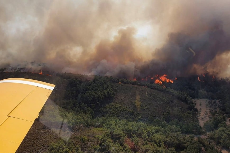 A Turkish firefighting plane flies over a wildfire burning on the island of Rhodes, Greece, July 24, 2023. Turkish Ministry of Agriculture and Forestry/Handout via REUTERS ATTENTION EDITORS - THIS IMAGE HAS BEEN PROVIDED BY A THIRD PARTY. MANDATORY CREDIT. NO RESALES. NO ARCHIVES.