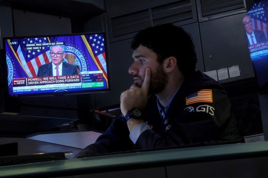 A trader works, as a screen displays a news conference by Federal Reserve Board Chairman Jerome Powell following the Fed rate announcement, on the floor of the New York Stock Exchange (NYSE) in New York City, U.S., July 26, 2023.  REUTERS/Brendan McDermid