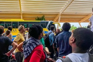 Ciudadanos franceses y de otras nacionalidades esperan en el aeropuerto internacional de Niamey, en Níger, parar ser transportados de regreso a Francia en un vuelo militar francés.