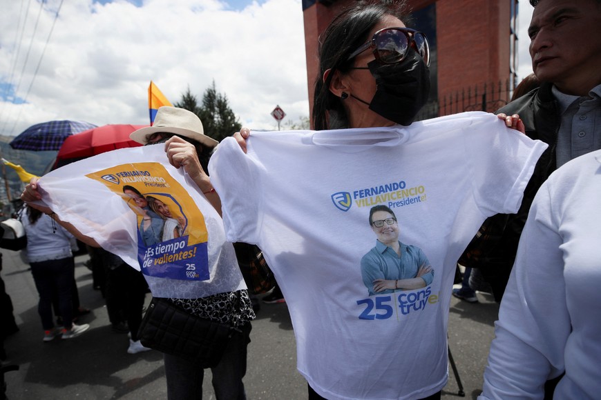 A woman holds a t-shirt with a picture of Ecuadorean presidential candidate Fernando Villavicencio, a vocal critic of corruption and organized crime, as friends, family members and supporters pay respect, after Villavicencio was killed during a campaign event, in Quito, Ecuador August 11, 2023. REUTERS/Henry Romero