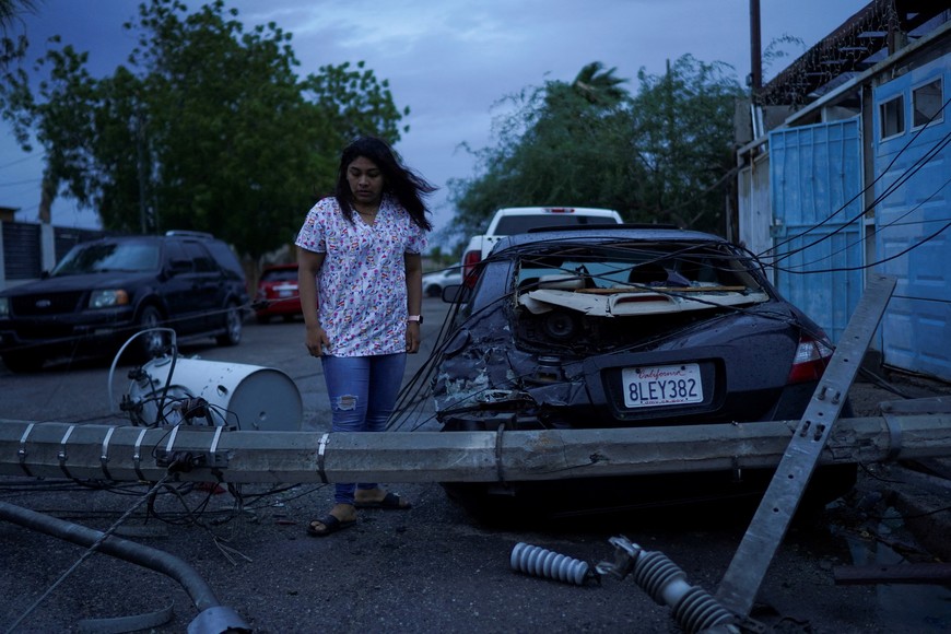 Laura Elizalde Reyes looks at a light pole that hit her car as Tropical Storm Hilary hits Baja California state, in Mexicali, Mexico, August 20, 2023. REUTERS/Victor Medina     TPX IMAGES OF THE DAY