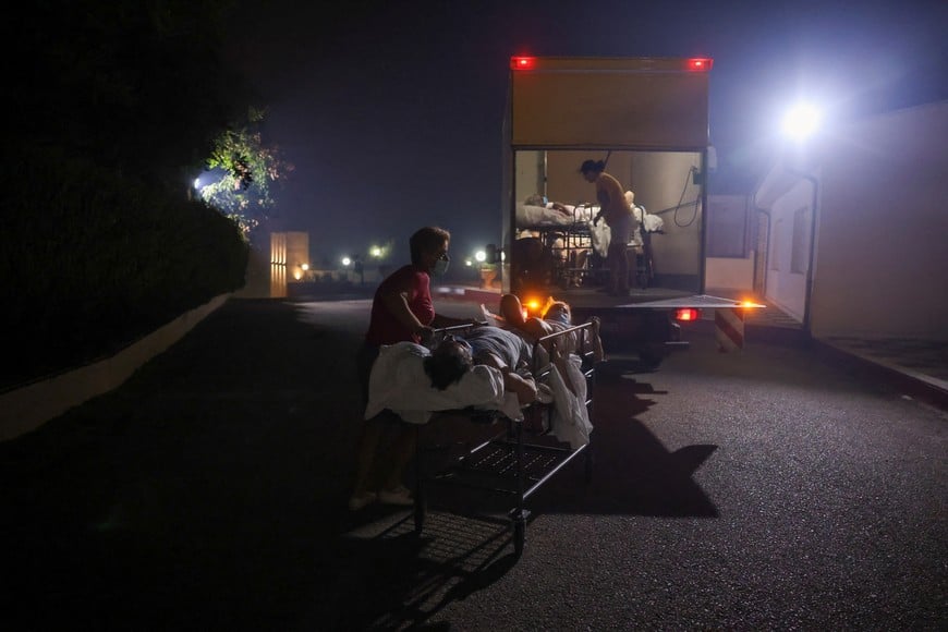 Patients of a chronic diseases management foundation get evacuated as a wildfire burns near Alexandroupolis, in the region of Evros, Greece, August 22, 2023. REUTERS/Alexandros Avramidis