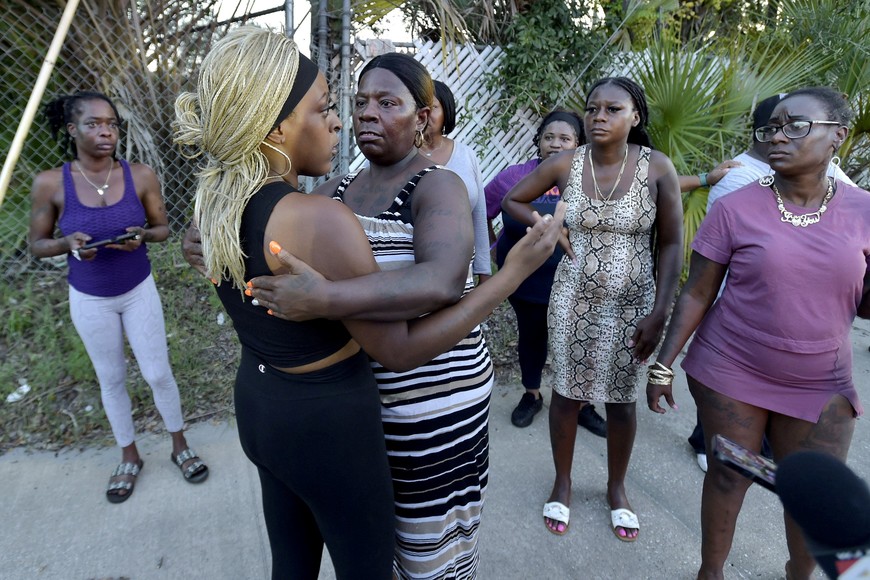 Neighborhood resident Virginia Bradford hugs a woman who came to the police line after going to the hospital to see her child and the child's father who she said were shot at the Dollar General Store, after police said a white man armed with a high-powered rifle and a handgun killed three Black people before shooting himself, in what local law enforcement described as a racially motivated crime in Jacksonville, Florida, U.S. August 26, 2023.  Bob Self/USA Today Network via REUTERS. 
NO RESALES. NO ARCHIVES. MANDATORY CREDIT