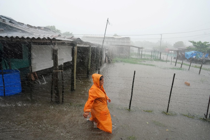 A woman walks on a flooded street as Storm Idalia makes landfall in Cuba, Guanimar, Cuba, August 28, 2023.  REUTERS/Alexandre Meneghini