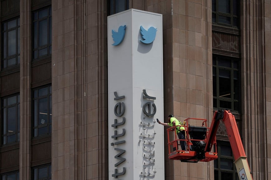 FILE PHOTO: A worker dismantles at Twitter's sign at Twitter's corporate headquarters building as Elon Musk renamed Twitter as X and unveiled a new logo, in downtown San Francisco, California, U.S., July 24, 2023. REUTERS/Carlos Barria/File Photo