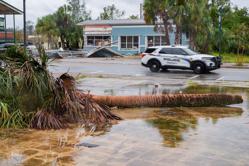 A police vehicle drives past a fallen palm tree after the arrival of Hurricane Idalia in Perry, Florida, U.S., August 30, 2023. REUTERS/Cheney Orr
