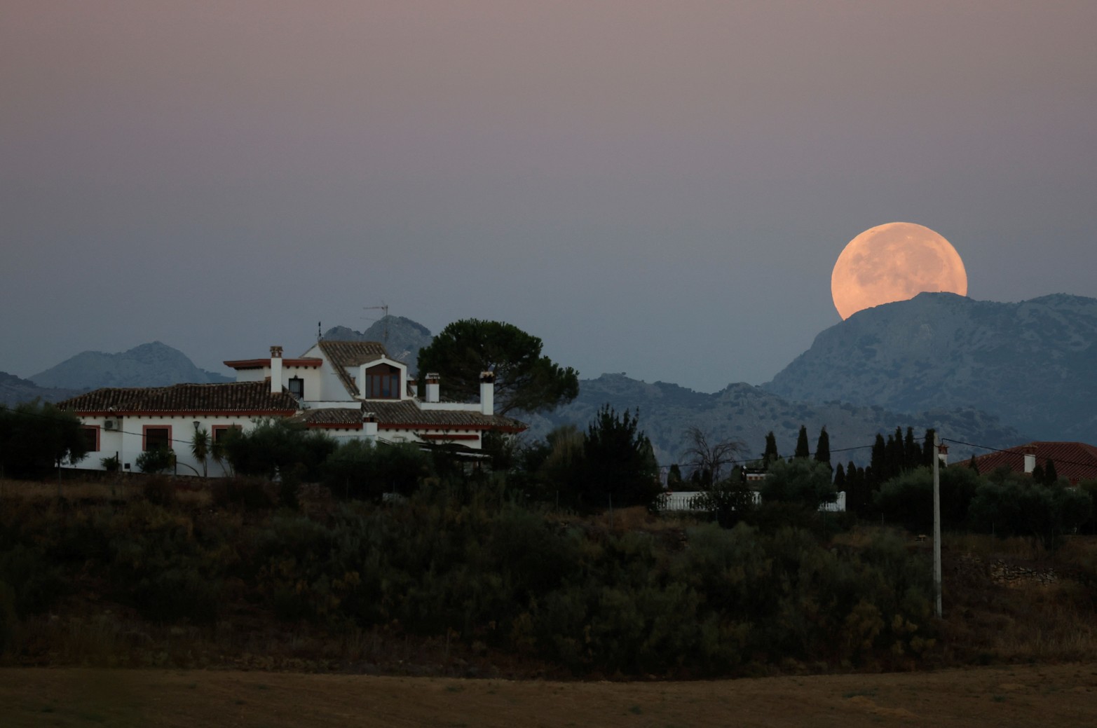 Una superluna, conocida como Luna Azul, se ve en el horizonte al amanecer en Ronda, España. Créditos: Jon Nazca/Reuters