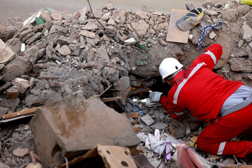 A worker looks through the rubble in the aftermath of a deadly earthquake in Talat N'Yaaqoub in Morocco September 12, 2023. REUTERS/Hannah McKay     TPX IMAGES OF THE DAY