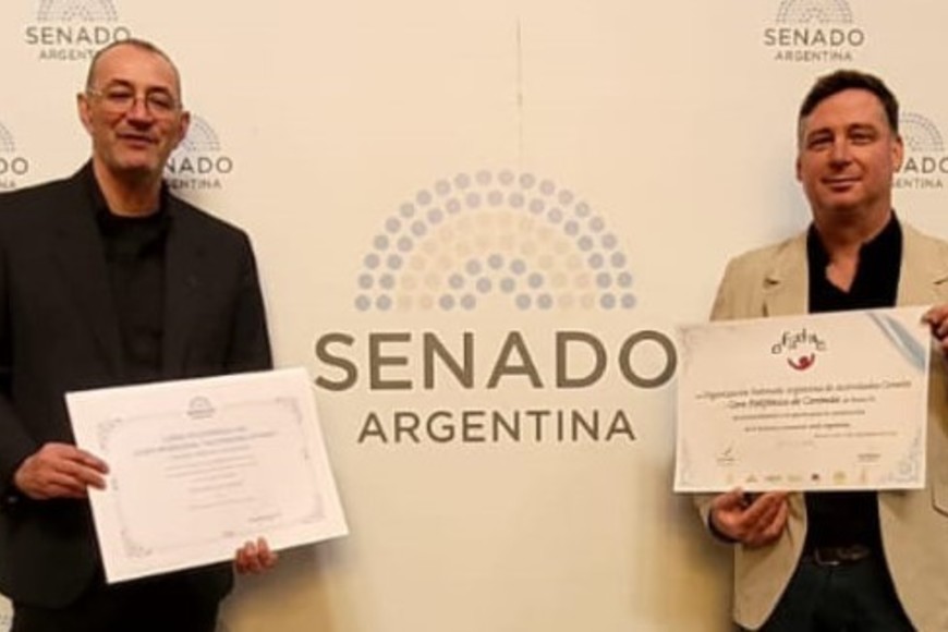 Los profesores Cristian Anghilante y Miguel Frutos recibiendo un reconocimiento para el Coro de Coronda, en el Senado de la Nación.