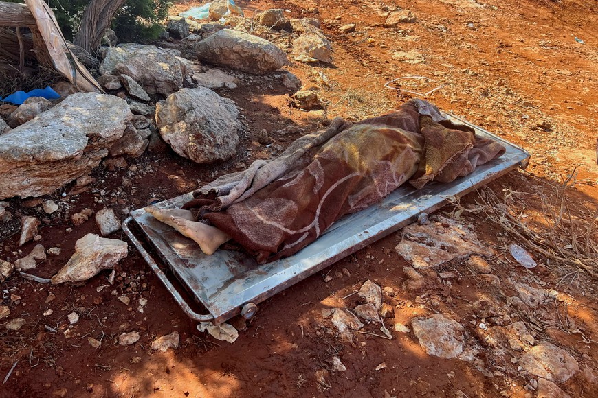 SENSITIVE MATERIAL. THIS IMAGE MAY OFFEND OR DISTURB The body of a victim lies on a stretcher before being placed at a mass grave after a powerful storm and heavy rainfall hit Libya, in Derna, Libya September 12, 2023. REUTERS/Ayman Al-Sahili