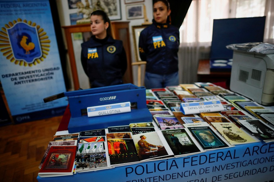 Police officers stand next to Nazi propaganda books, after a raid carried out by Argentina's Anti-Terrorist Investigation Unit Department, where they arrested a man leading a propaganda distribution operation, in Buenos Aires, Argentina September 13, 2023. REUTERS/Agustin Marcarian