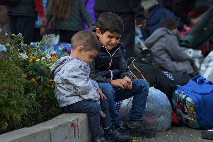 Children sit on a curb as residents gather in central Stepanakert to leave Nagorno-Karabakh, a region inhabited by ethnic Armenians, September 25, 2023. After a lightning operation by Azerbaijan's military to retake control of Nagorno-Karabakh, the stream of ethnic Armenians fleeing the region to Armenia quickly turned into a flood.  REUTERS/David Ghahramanyan     SEARCH "GHAHRAMANYAN NAGORNO-KARABAKH" FOR THIS STORY. SEARCH "WIDER IMAGE" FOR ALL STORIES.