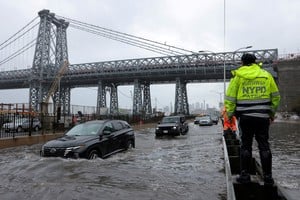 FILE PHOTO: A police officer from the NYPD Highway Patrol looks on as motorists drive through a flooded street after heavy rains as the remnants of Tropical Storm Ophelia bring flooding across the mid-Atlantic and Northeast, at the FDR Drive in Manhattan near the Williamsburg Bridge, in New York City, U.S., September 29, 2023.  REUTERS/Andrew Kelly/File Photo