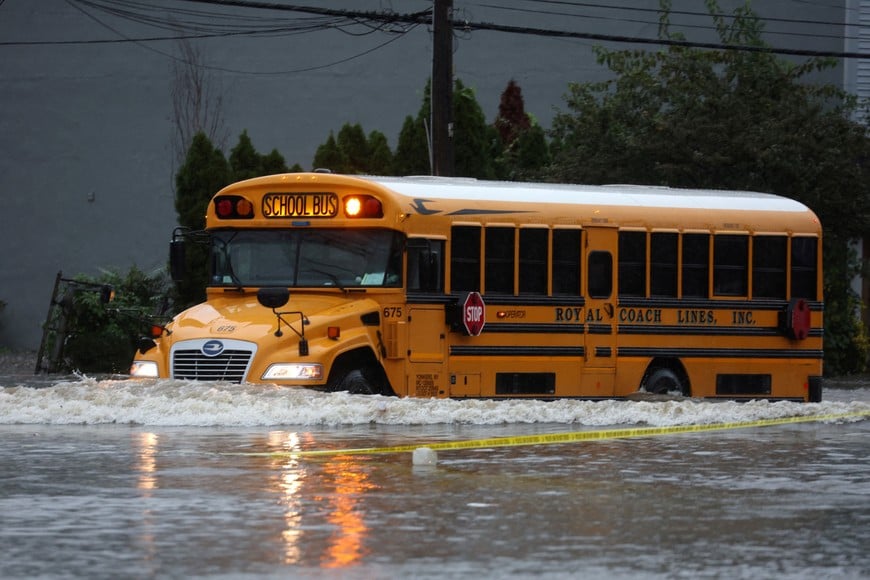 A school bus drives through heavy flooding in the New York City suburb of Larchmont, New York, U.S., September 29, 2023. REUTERS/Mike Segar