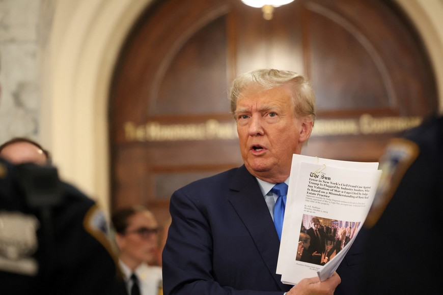 Former U.S. President Donald Trump holds papers at a Manhattan courthouse, where he attends the trial of himself, his adult sons, the Trump Organization and others in a civil fraud case brought by state Attorney General Letitia James, in New York City, U.S., October 2, 2023. REUTERS/Brendan McDermid