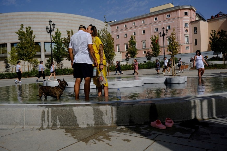 Madrid residents Raquel and Nasser cool off at a fountain with their dog Romeo during the third heatwave of the summer in Madrid, Spain, August 8, 2023. REUTERS/Susana Vera     TPX IMAGES OF THE DAY