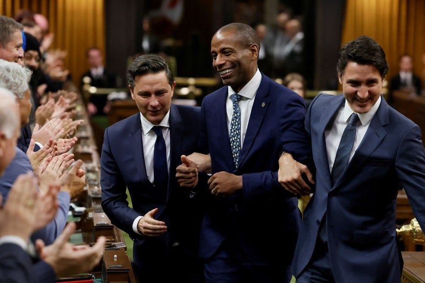 Newly elected Speaker Greg Fergus pretends to resist while being walked through the House of Commons by Canada's Prime Minister Justin Trudeau and Conservative Party of Canada leader Pierre Poilievre on Parliament Hill in Ottawa, Ontario, Canada October 3, 2023. REUTERS/Blair Gable