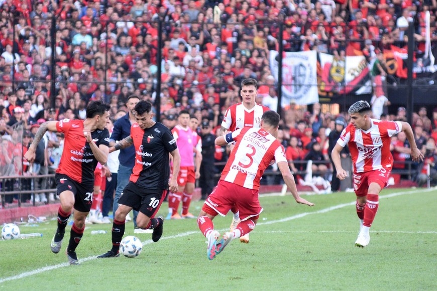 Botta se lleva la pelota y Meza le pasa por detrás ante la marca a presión, sobre la raya, de los jugadores de Unión. Uno está en duda (Botta) y el otro volvería al equipo (Meza) en reemplazo del desgarrado Espínola. Crédito: Pablo Aguirre.