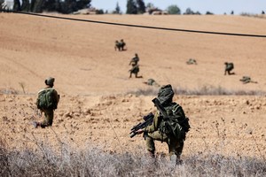 Israeli soldiers take position at Kibbutz Kfar Aza, in southern Israel, October 10, 2023. REUTERS/Ronen Zvulun
