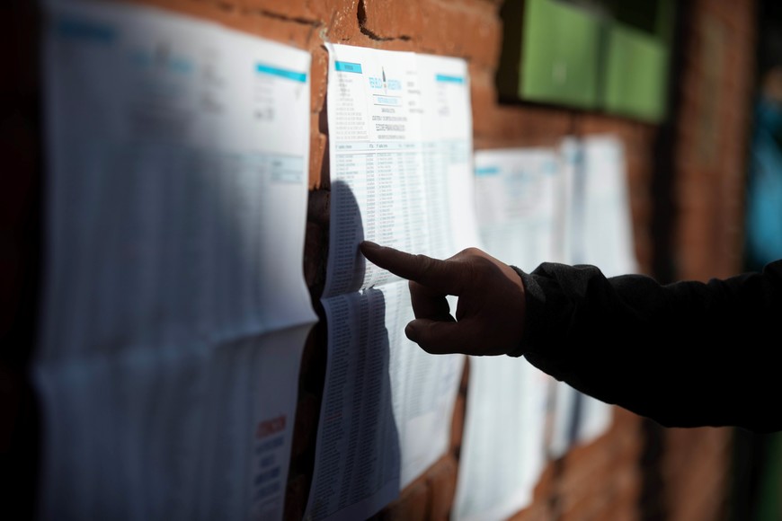 (230813) -- BUENOS AIRES, 13 agosto, 2023 (Xinhua) -- Un hombre busca su mesa de votación en los padrones electorales pegados en la fachada de una escuela durante las elecciones Primarias, Abiertas, Simultáneas y Obligatorias (PASO), en Buenos Aires, Argentina, el 13 de agosto de 2023. Los centros de votación para las elecciones PASO de Argentina se abrieron el domingo a las 08:00 hora local (11:00 GMT). (Xinhua/Martín Zabala) (mz) (oa) (ah) (da)