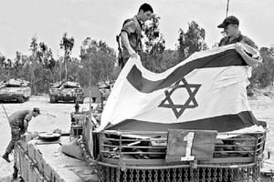 En señal de triunfo, soldados israelíes despliegan una bandera de su país sobre un vehículo de combate de las fuerzas enemigas durante la llamada Guerra de los Seis Días (del 5 al 10 de junio de 1967).