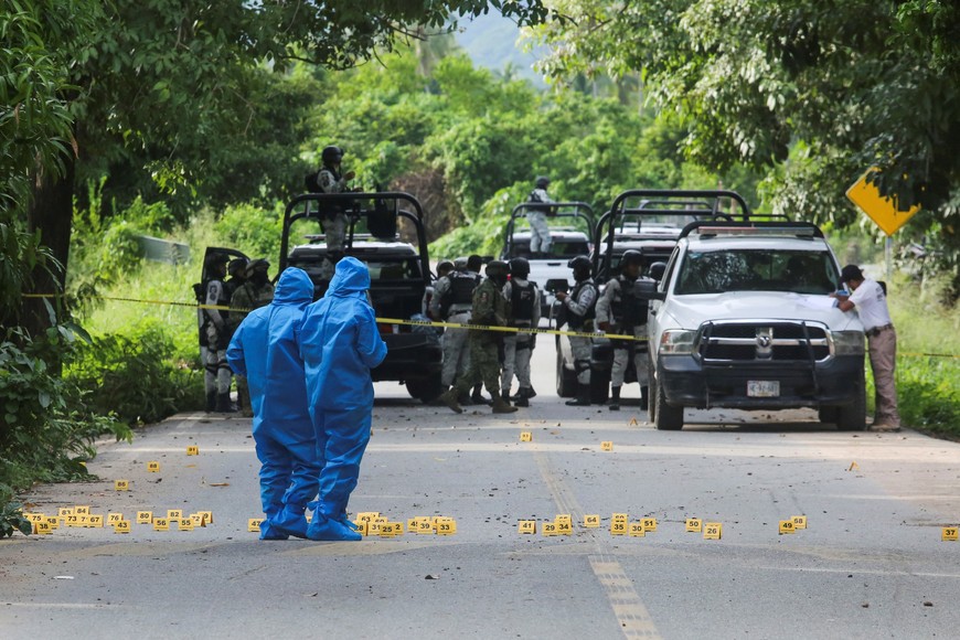 Forensic technicians work at a crime scene where several local police officers were shot dead by gunmen, in Coyuca de Benitez, Mexico October 23, 2023. REUTERS/Javier Verdin