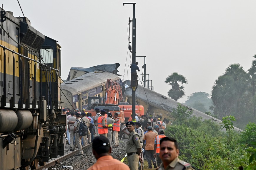 Rescue workers and police officials stand next to damaged coaches following a collision between two passenger trains in Vizianagaram district in the southern Andhra Pradesh state, India, October 30, 2023. REUTERS/R.Narendra NO RESALES. NO ARCHIVES