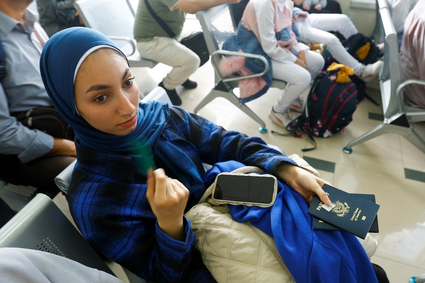 A Palestinian woman holding a U.S. passport, waits for permission to leave Gaza, amid the ongoing conflict between Israel and Palestinian Islamist group Hamas, at the Rafah border crossing with Egypt, in Rafah in the southern Gaza Strip, November 2, 2023. REUTERS/Ibraheem Abu Mustafa