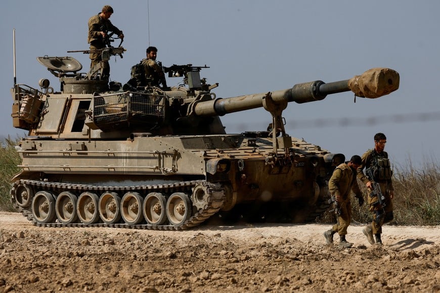Israeli soldiers from an artillery unit ride a military vehicle near the Israeli side of the border between Israel and the Gaza Strip, November 3, 2023. REUTERS/Amir Cohen