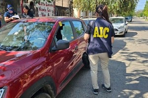 Peritos de la AIC inspeccionan el vehículo baleado. Crédito: El Litoral.