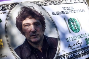 FILE PHOTO: A 100-dollar bill cut-out with Argentine presidential candidate Javier Milei's face printed on it is pictured during the closing event of his electoral campaign ahead of the November 19 runoff election, in Cordoba, Argentina, November 16, 2023. REUTERS/Matias Baglietto/File Photo