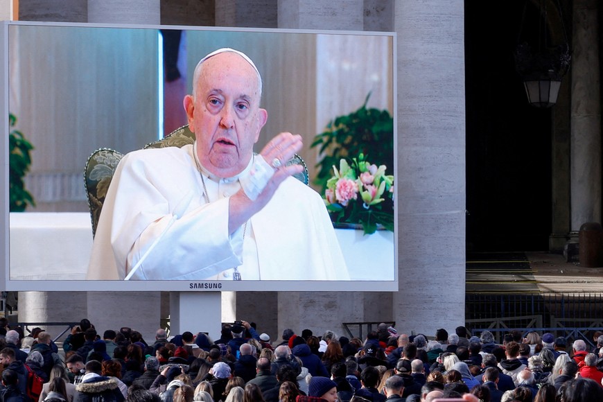 Pope Francis blesses faithful as he appears on a screen in St. Peter's Square, while leading the Angelus prayer from Santa Marta chapel at the Vatican, November 26, 2023. REUTERS/Remo Casilli