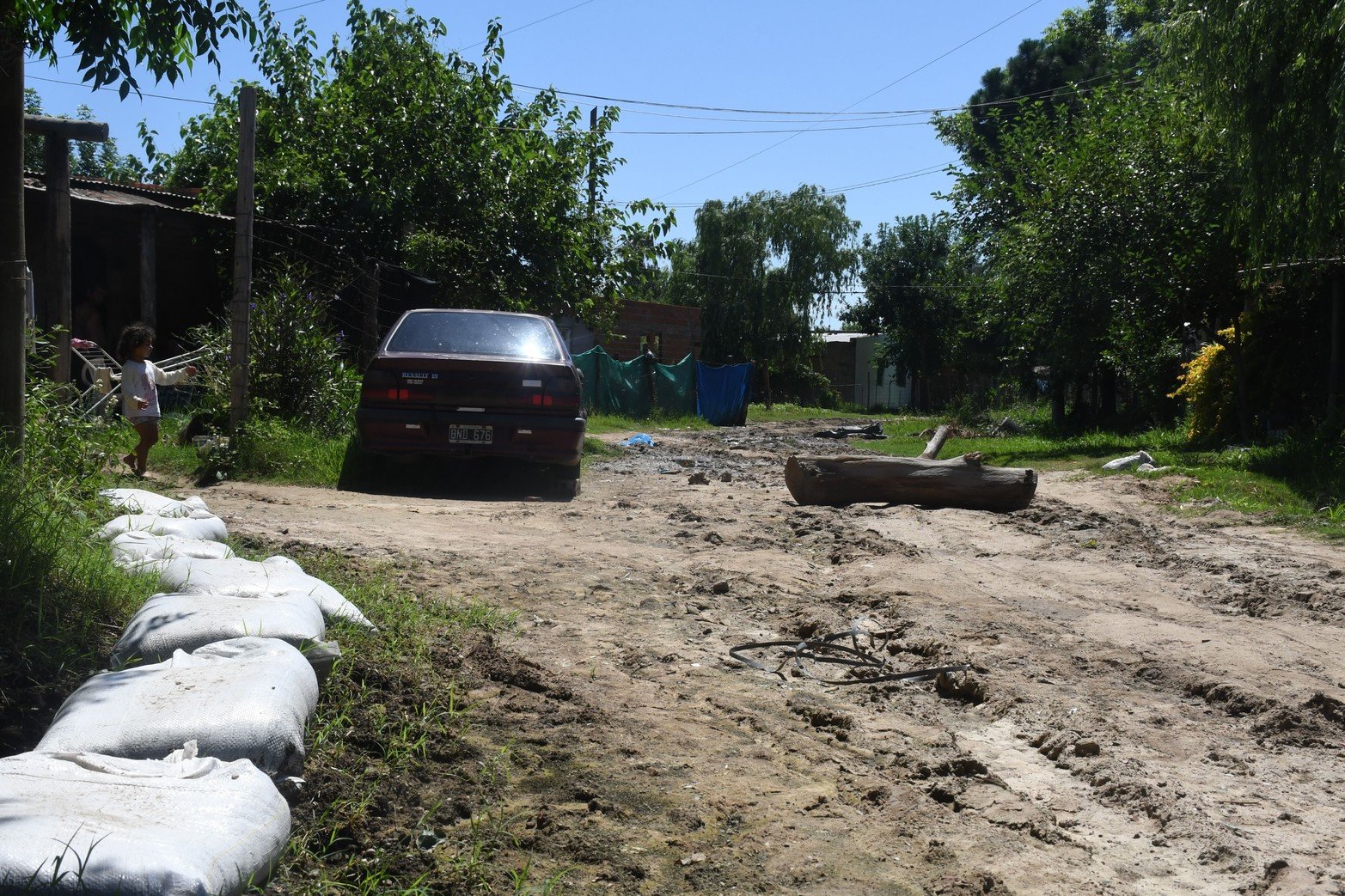 Calle sin nombre y Vicente Zarza vecinos colocan bolsas de arena para poder salir  caminando a una calle más alta y un tronco que impide el paso de vehículos.  Foto Flavio Raina