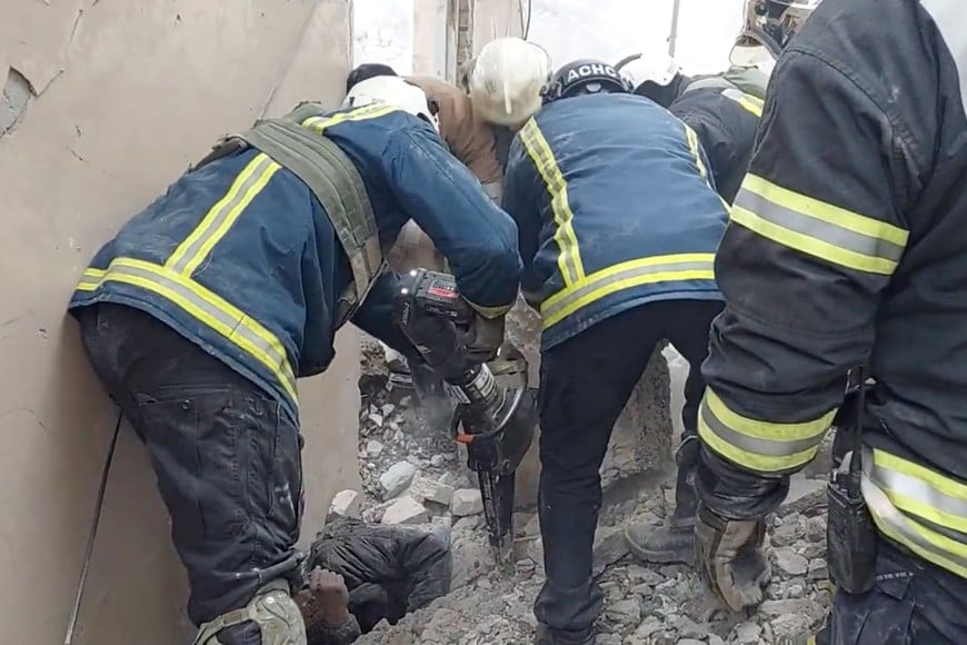 Rescuers help free a man from under the rubble in an aftermath of an attack, amid Russia's attack on Ukraine, in a location given as Kharkiv, Ukraine, in this screen grab obtained from a handout video released on December 29, 2023.  State Emergency Service Of Ukraine/Handout via REUTERS   THIS IMAGE HAS BEEN SUPPLIED BY A THIRD PARTY. MANDATORY CREDIT