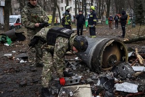 A bomb squad member works next to a part of a Russian missile at the site where residential buildings were heavily damaged during a Russian missile attack, amid Russia's attack on Ukraine, in central Kharkiv, Ukraine January 2, 2024. REUTERS/Sofiia Gatilova