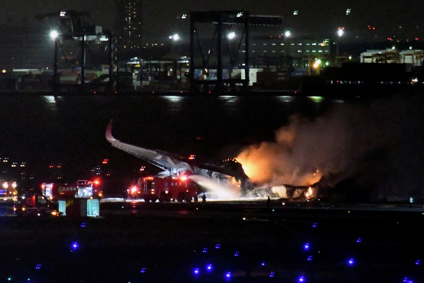 (240102) -- TOKIO, 2 enero, 2024 (Xinhua) -- Bomberos trabajan en el sitio de una colisión de aviones en el aeropuerto de Haneda, en Tokio, Japón, el 2 de enero de 2024. Se confirmó que una persona a bordo del avión de la Guardia Costera de Japón que chocó con un avión de Japan Airlines en el aeropuerto de Haneda, en Tokio, sobrevivió el martes al incidente, mientras que las otras cinco personas restantes están actualmente desaparecidas, informaron medios de comunicación locales. El avión de la Guardia Costera transportaba artículos de socorro para las zonas afectadas por el terremoto en la prefectura de Niigata, después de que una serie de sismos de magnitud de hasta 7,6 sacudieran el centro de Japón el lunes por la tarde, dijo la emisora pública NHK citando a la Guardia Costera. Además, los 367 pasajeros y 12 miembros de la tripulación a bordo del avión de Japan Airlines que se incendió en el aeropuerto de Haneda han sido evacuados, según NHK. El avión, con el vuelo 516 de Japan Airl