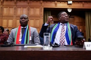 South Africa's Minister of Justice Ronald Lamola and South African Ambassador to the Netherlands Vusimuzi Madonsela sit inside the International Court of Justice (ICJ) as judges hear a request for emergency measures by South Africa to order Israel to stop its military actions in Gaza, in The Hague, Netherlands January 12, 2024. REUTERS/Thilo Schmuelgen