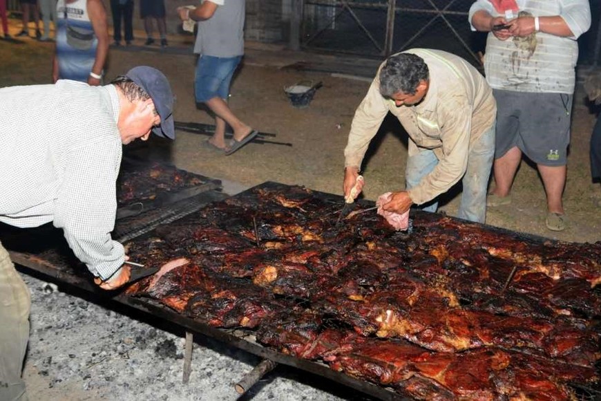 Los asadores cortando la carne para comenzar a servir.