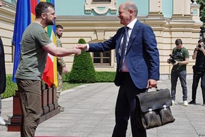 El presidente ucraniano Volodimir Zelenski saluda al canciller alemán Olaf Scholz, inseparable de su viejo maletín negro.