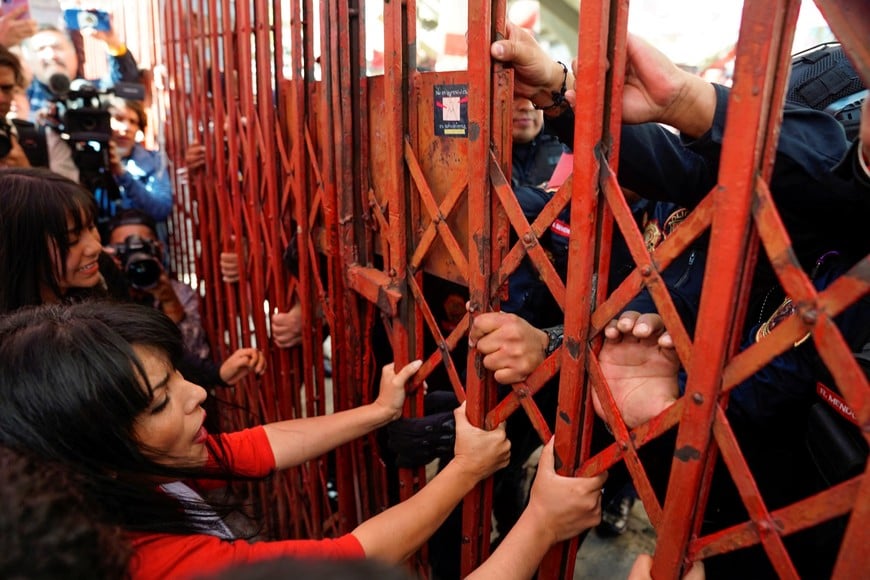 Demonstrators try to open a fence, as police officers hold it from the other side, as part of a protest against the return of bullfighting, outside the Plaza de Toros Mexico bullfighting ring, in Mexico City, Mexico, January 28, 2024. REUTERS/Toya Sarno Jordan