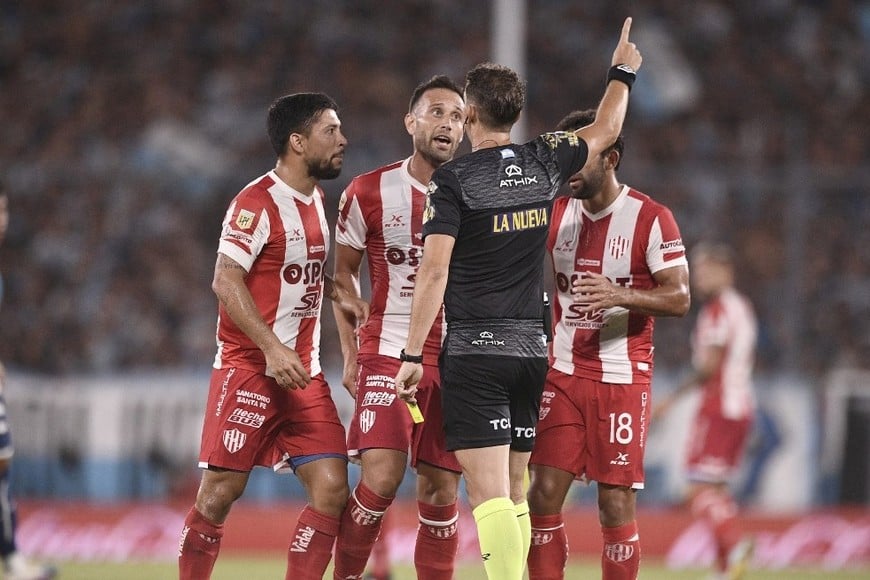 Luna Diale, Corvalán y Gamba "apuran" a Nicolás Lamolina en el momento en que el árbitro esperó el llamado desde el VAR en la jugada en tiempo de descuento en la que Racing pidió penal de Tanda, pero Lamolina observó un foul previo en perjuicio de Paz y terminó cobrando tiro libre para Unión. Crédito: Manuel Nápoli.