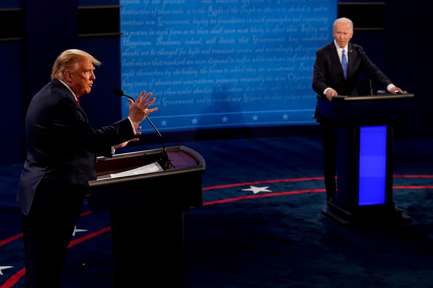 U.S. President Donald Trump answers a question as Democratic presidential candidate former Vice President Joe Biden listens during the final presidential debate at the Curb Event Center at Belmont University in Nashville, Tennessee, U.S., October 22, 2020. Morry Gash/Pool via REUTERS  REFILE - CORRECTING BYLINE